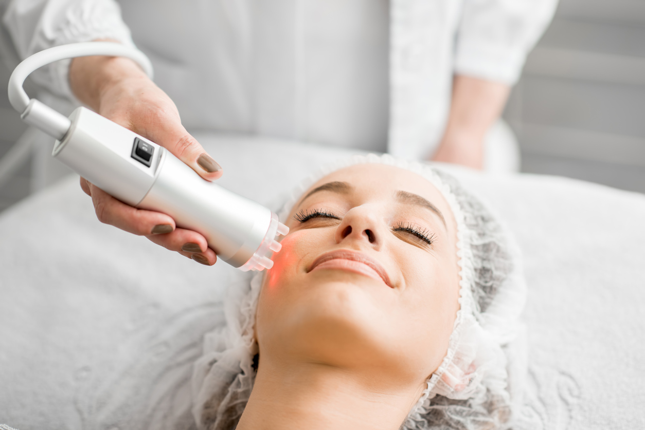 Young woman during a facial massage with professional tool at the medical center